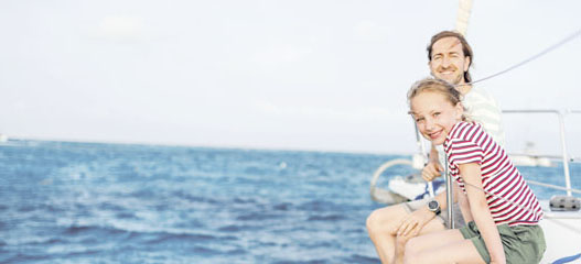 padre e hija sentados en la cubierta de una embarcación