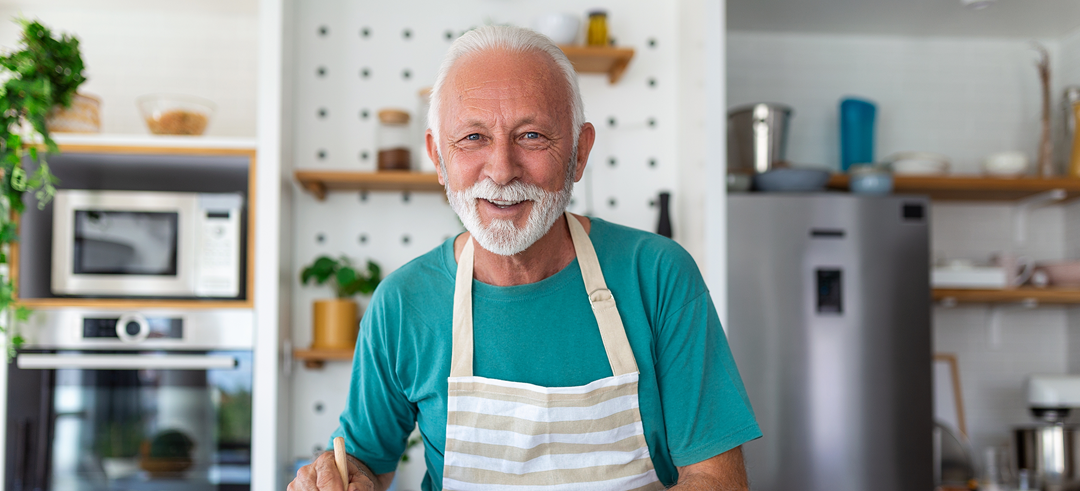 Hombre adulto cocinando en la cocina de su casa