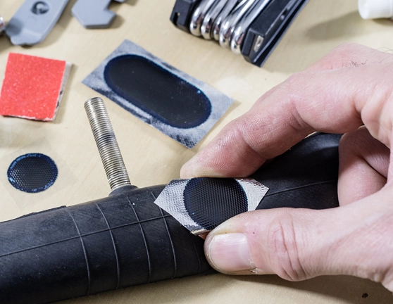 Persona arreglando el pinchazo de la rueda de una bicicleta